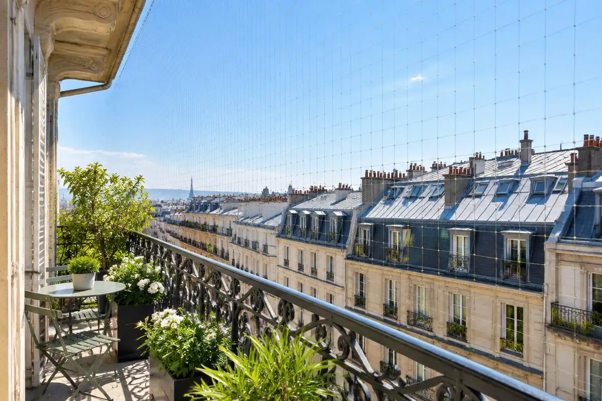Balcon parisien protégé par un filet anti-oiseaux discret, illustration